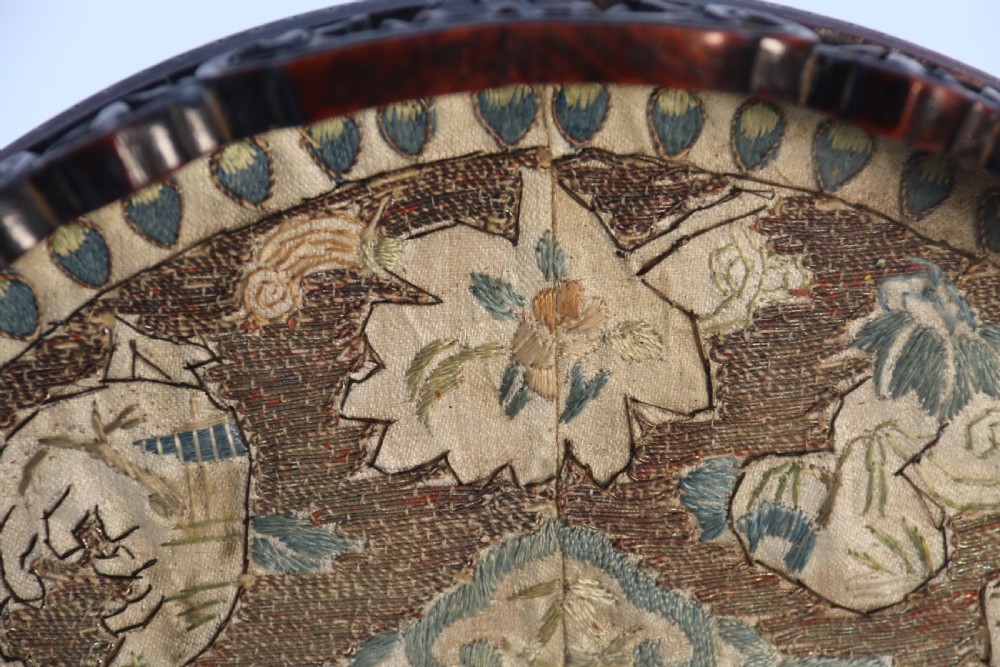A circular carved dark hardwood tray containing an inset 19th-century Chinese silk embroidery with figural and botanical motifs. View XIII