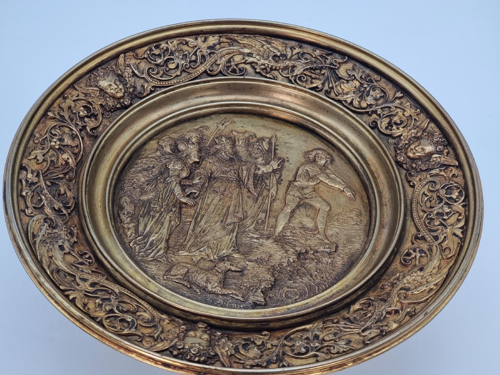 An Aesthetic Movement circular gilt metal tazza on a pedestal foot featuring ornate foliate scrollwork and a central relief medallion. View XI