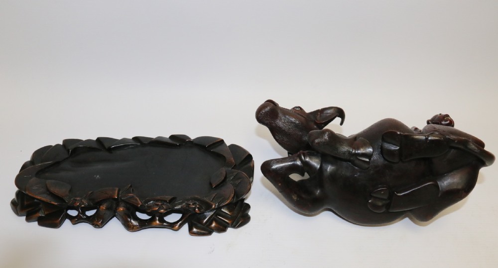 A pair of late Qing dynasty hand-carved dark hardwood water buffaloes, each mounted on a pierced wooden base and depicting a small boy resting on its back. View XII