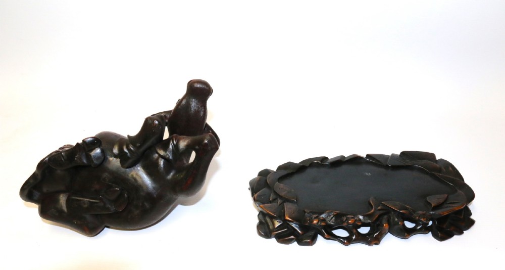A pair of late Qing dynasty hand-carved dark hardwood water buffaloes, each mounted on a pierced wooden base and depicting a small boy resting on its back. View XVI