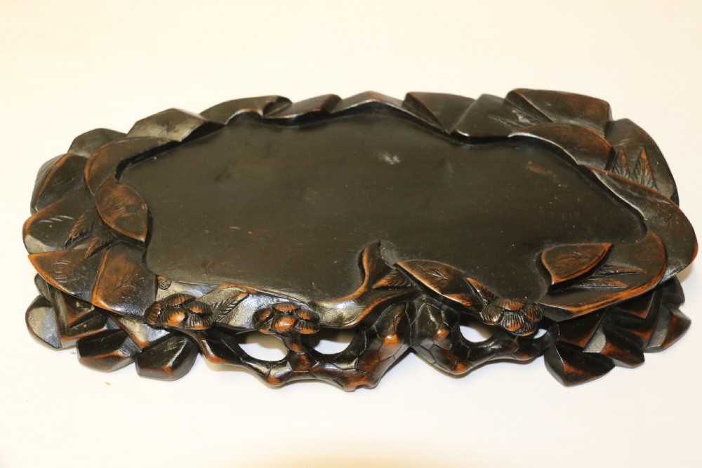 A pair of late Qing dynasty hand-carved dark hardwood water buffaloes, each mounted on a pierced wooden base and depicting a small boy resting on its back. View XVII