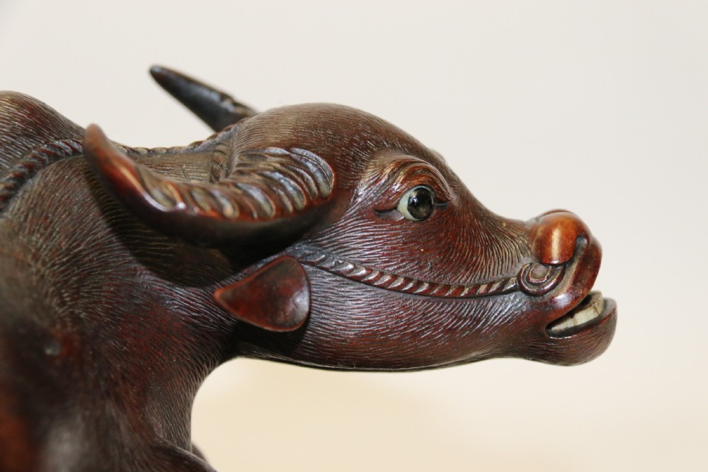 A pair of late Qing dynasty hand-carved dark hardwood water buffaloes, each mounted on a pierced wooden base and depicting a small boy resting on its back. View XVIII