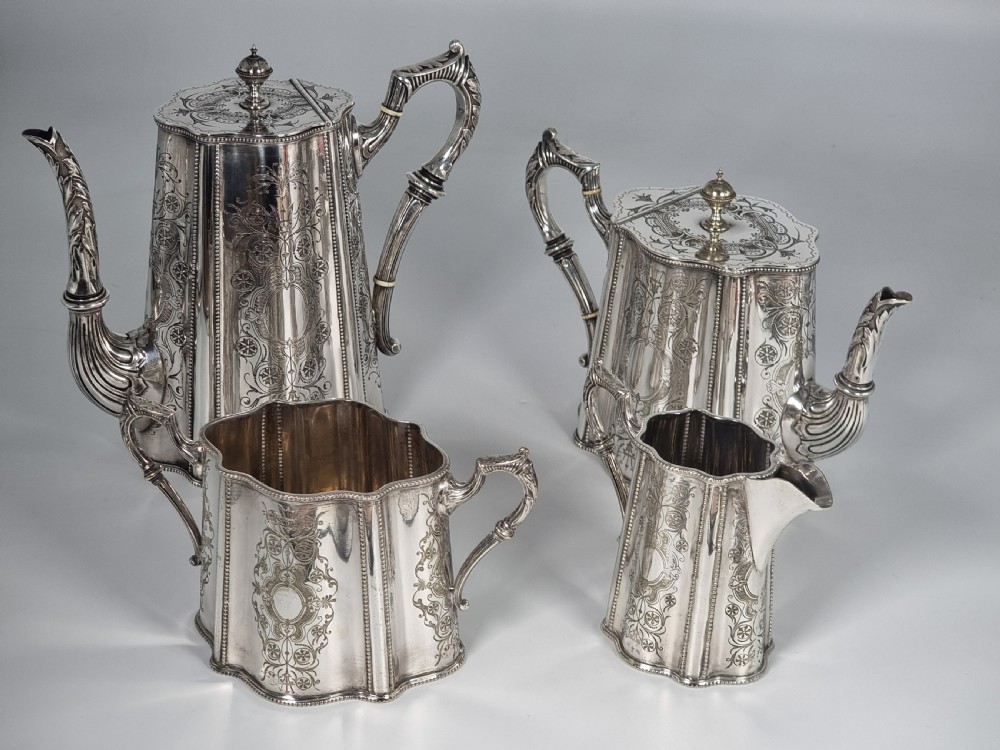 A four-piece Victorian silver-plated tea and coffee set featuring detailed engraving, fluted panels, and decorative handles. View II