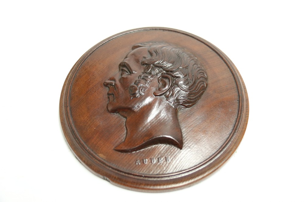 A pair of circular carved mahogany wall plaques featuring raised profile relief busts of classical composers Rossini and Auber. View IV