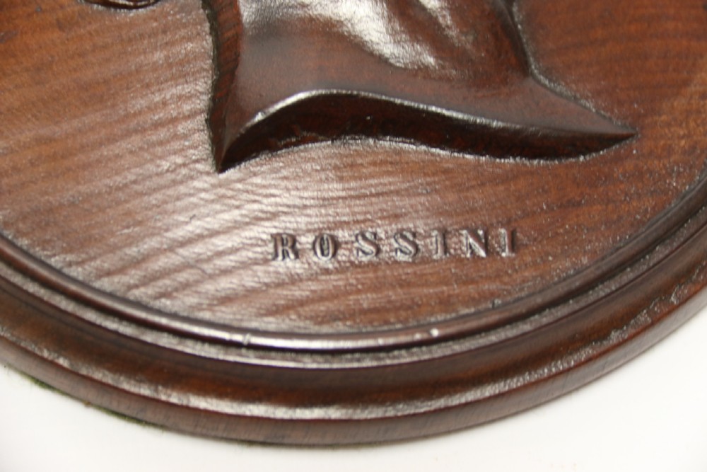 A pair of circular carved mahogany wall plaques featuring raised profile relief busts of classical composers Rossini and Auber. View VI