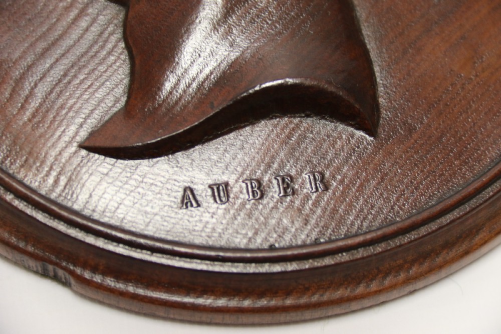 A pair of circular carved mahogany wall plaques featuring raised profile relief busts of classical composers Rossini and Auber. View VII