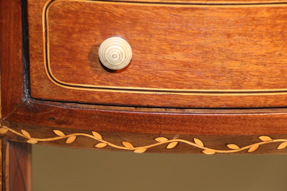 An oval George III satinwood worktable featuring marquetry inlay, multiple drawers, tapered legs, and a rising mirror compartment. View VII