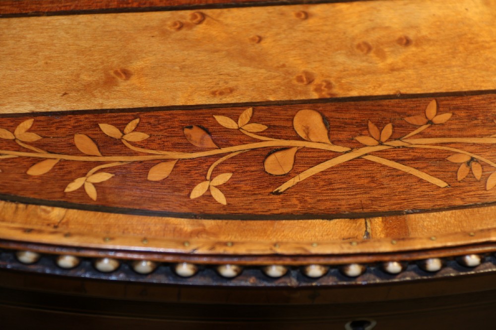 An oval George III satinwood worktable featuring marquetry inlay, multiple drawers, tapered legs, and a rising mirror compartment. View IX