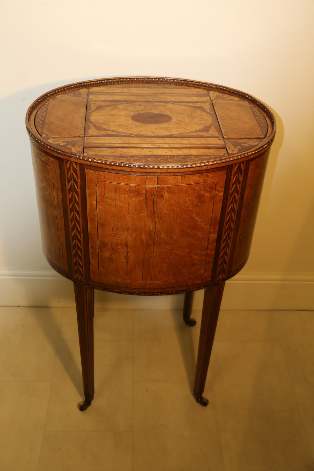 An oval George III satinwood worktable featuring marquetry inlay, multiple drawers, tapered legs, and a rising mirror compartment. View XI