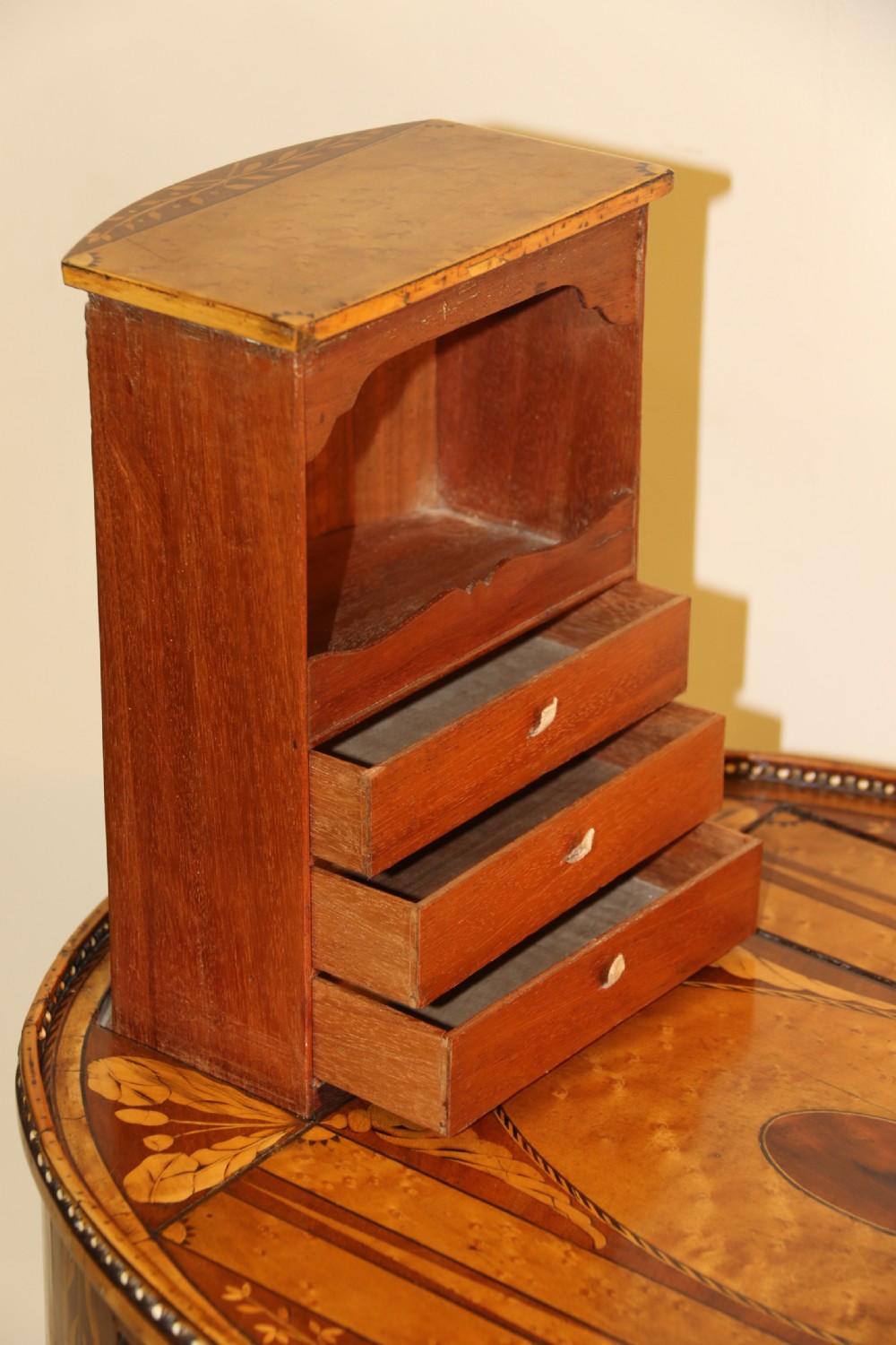 An oval George III satinwood worktable featuring marquetry inlay, multiple drawers, tapered legs, and a rising mirror compartment. View XIII