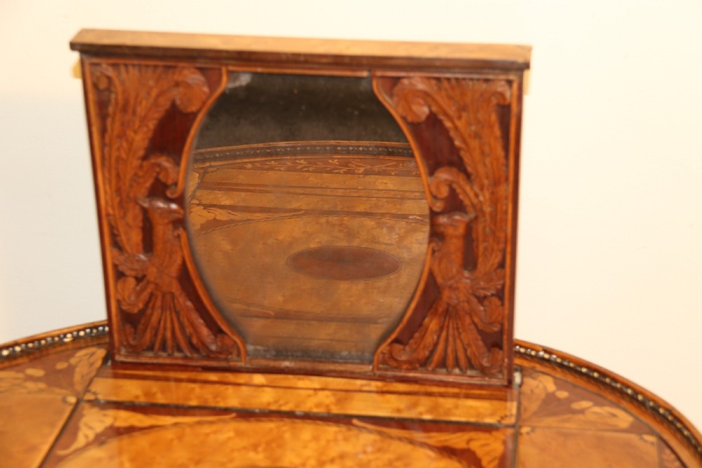 An oval George III satinwood worktable featuring marquetry inlay, multiple drawers, tapered legs, and a rising mirror compartment. View XVI