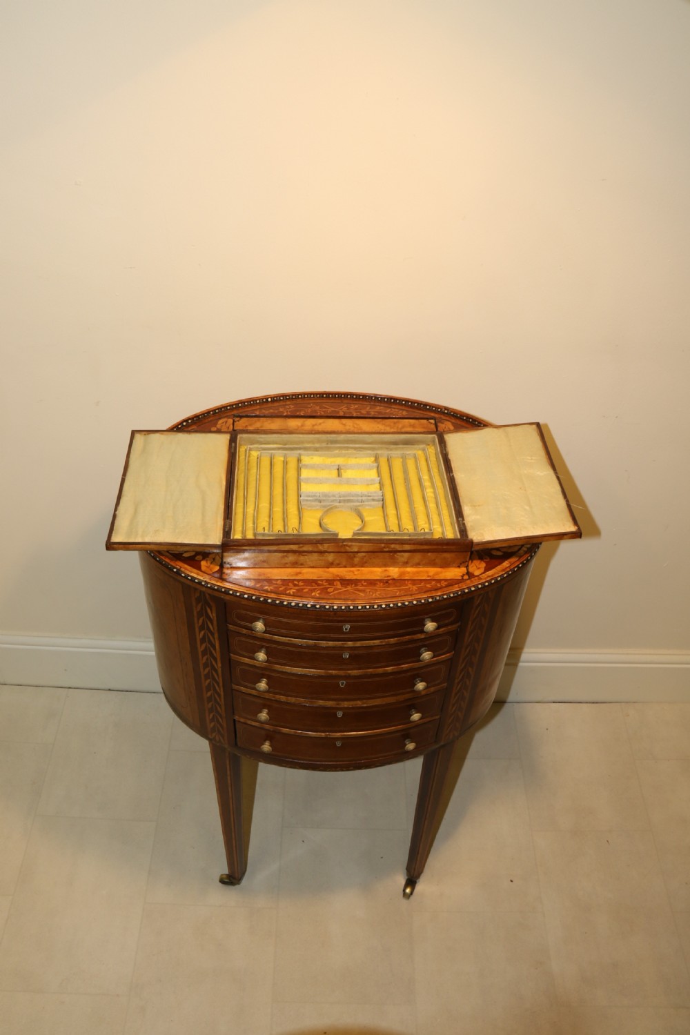 An oval George III satinwood worktable featuring marquetry inlay, multiple drawers, tapered legs, and a rising mirror compartment. View XVIII