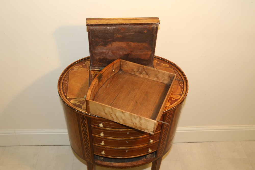 An oval George III satinwood worktable featuring marquetry inlay, multiple drawers, tapered legs, and a rising mirror compartment. View XX