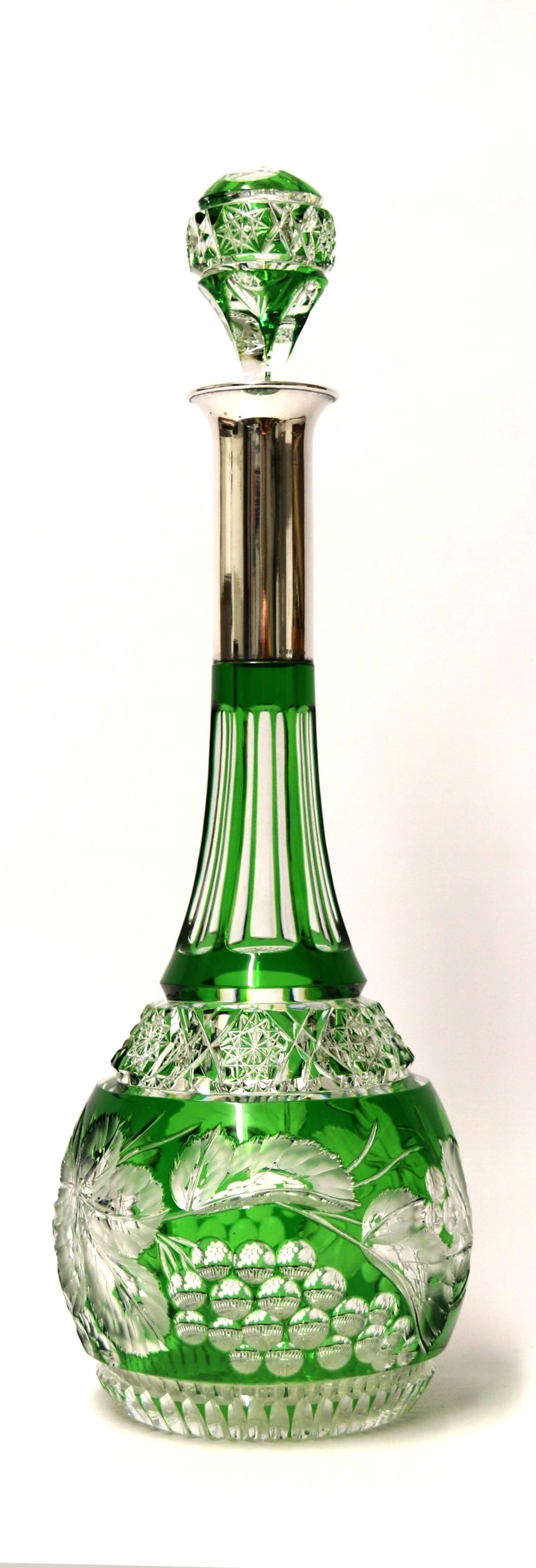 A Bohemian silver topped green overlaid and deeply cut and carved glass spirit decanter.