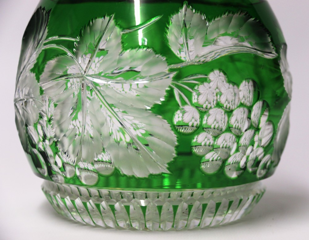 A Bohemian silver topped green overlaid and deeply cut and carved glass spirit decanter. View II