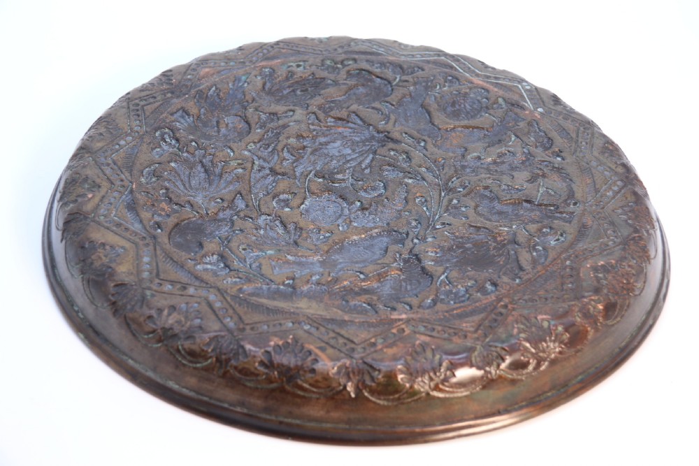 A circular copper repousse charger featuring relief carvings of birds, flowers, and geometric borders. View XI