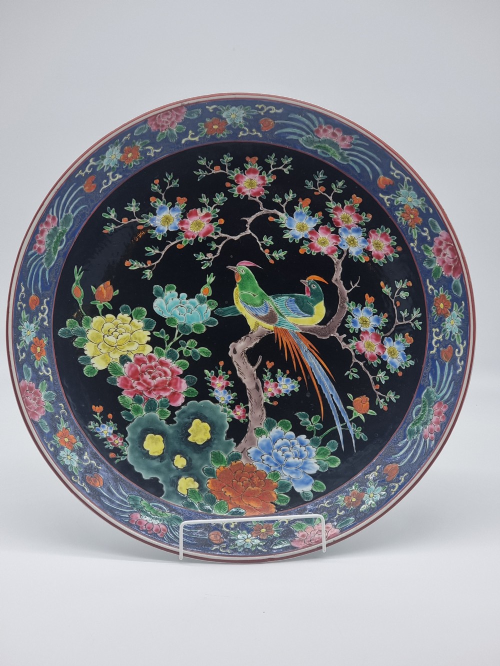 A large Chinese wall charger in famille noire porcelain