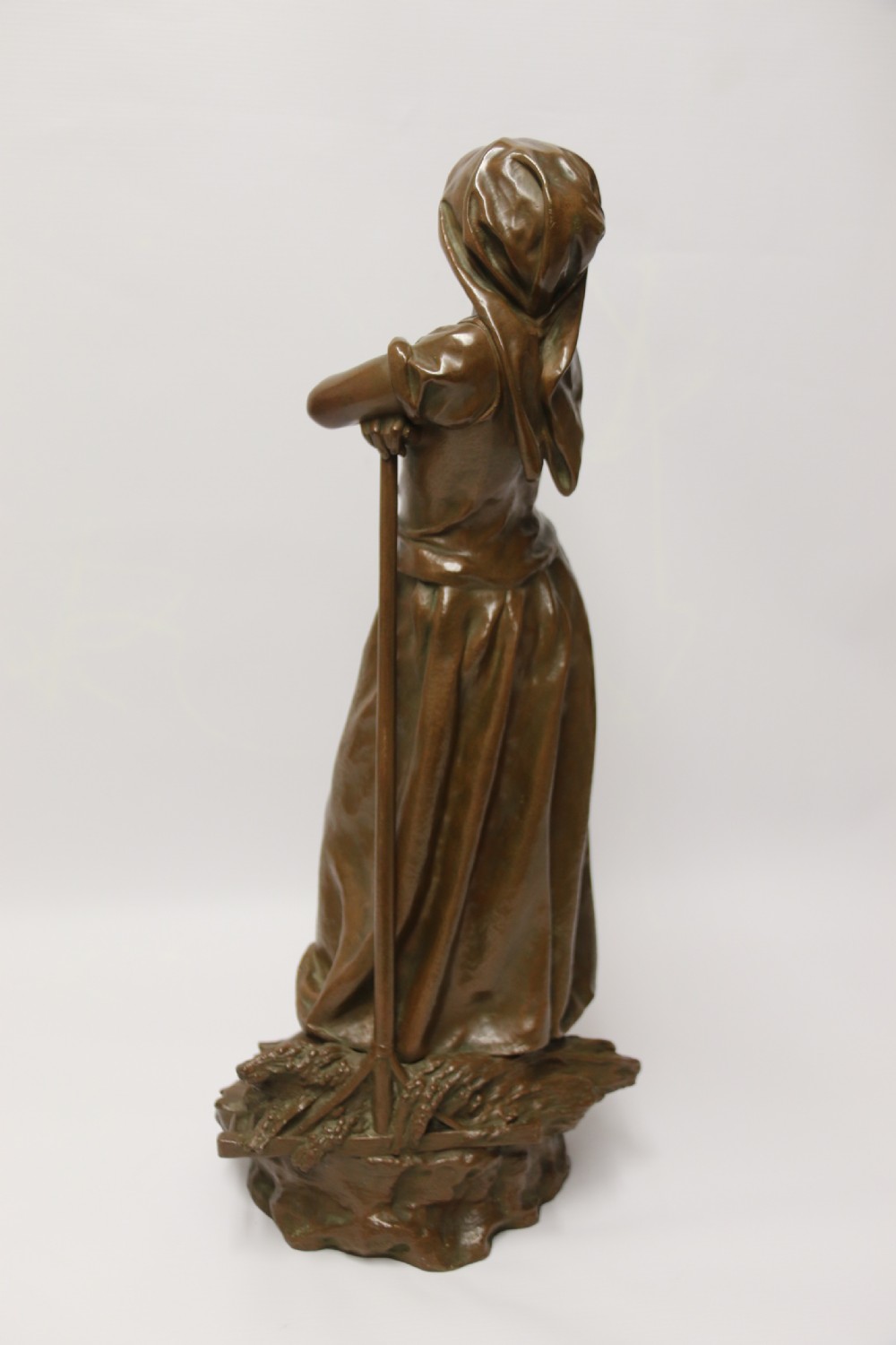 A 19th century  French bronze sculpture of a young female gathering hey at harvest View V