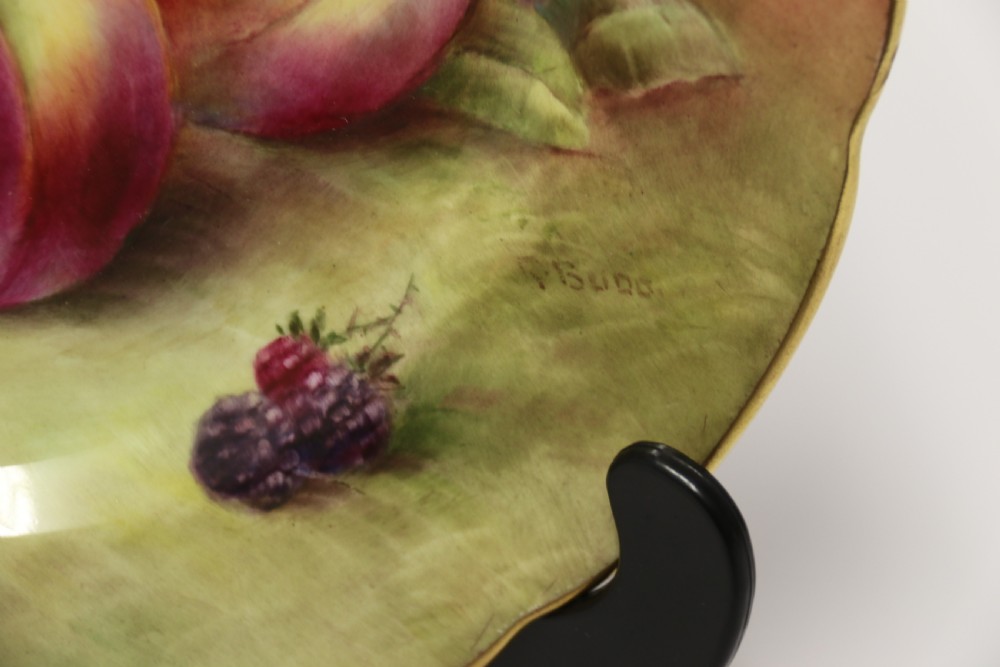 A pair of circular hand-painted porcelain plates displaying still life compositions of peaches, grapes, and blackberries framed by gilded scalloped edges. View XI