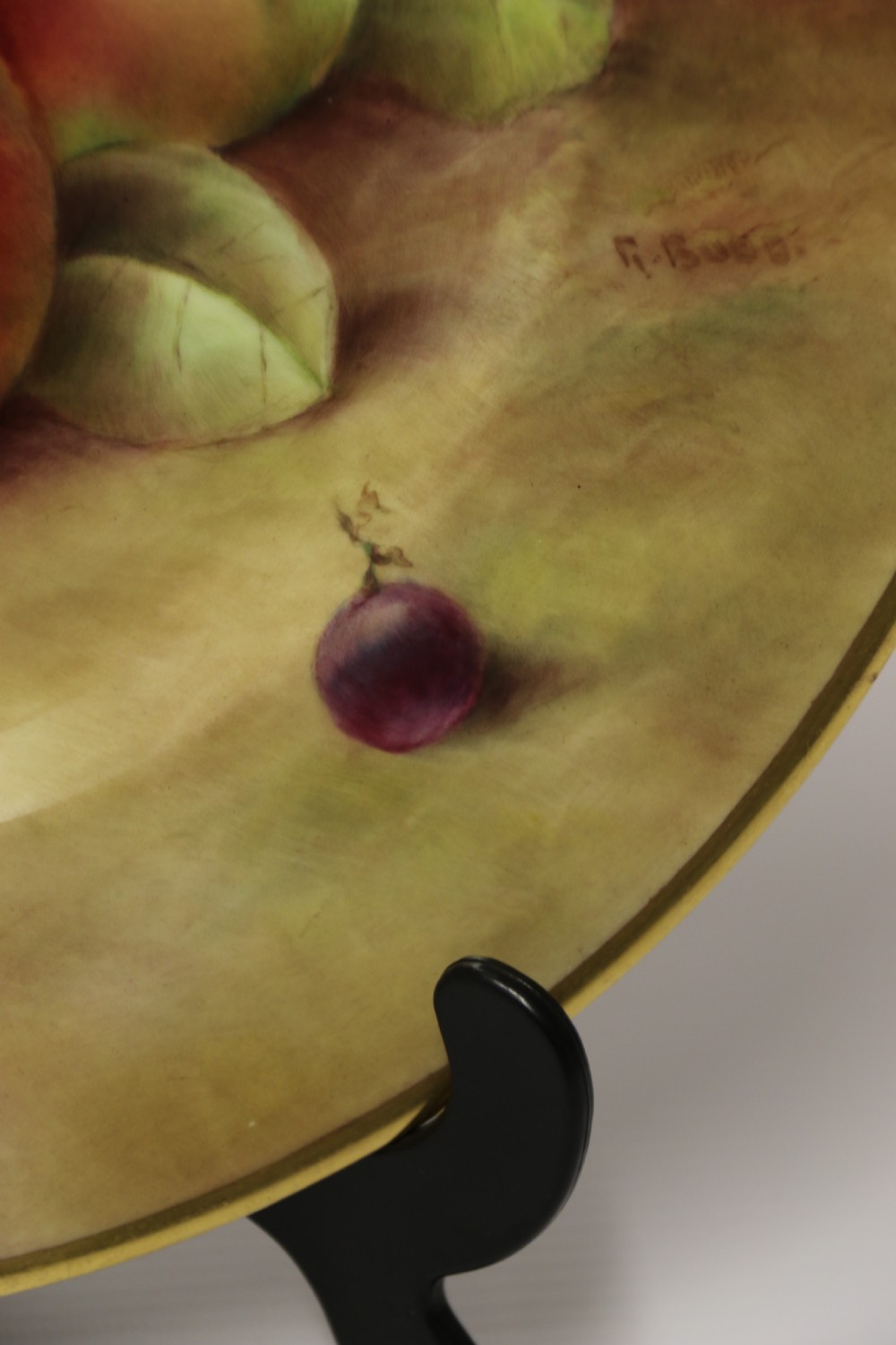 A pair of circular hand-painted porcelain plates displaying still life compositions of peaches, grapes, and blackberries framed by gilded scalloped edges. View XIX