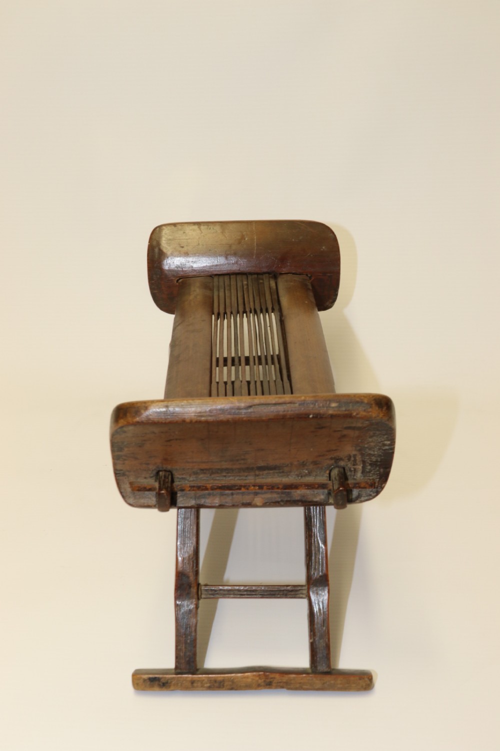 An eighteenth-century Chinese folding headrest crafted from dark bamboo and carved timber supports. View III