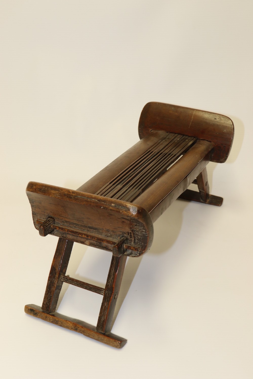 An eighteenth-century Chinese folding headrest crafted from dark bamboo and carved timber supports. View IV