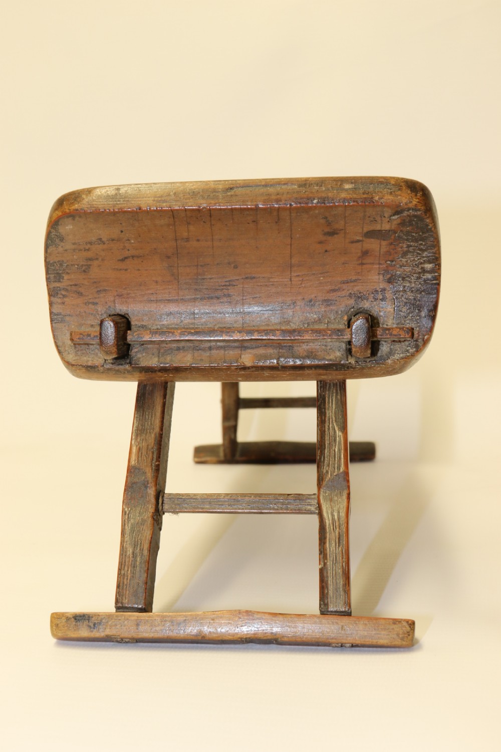 An eighteenth-century Chinese folding headrest crafted from dark bamboo and carved timber supports. View V