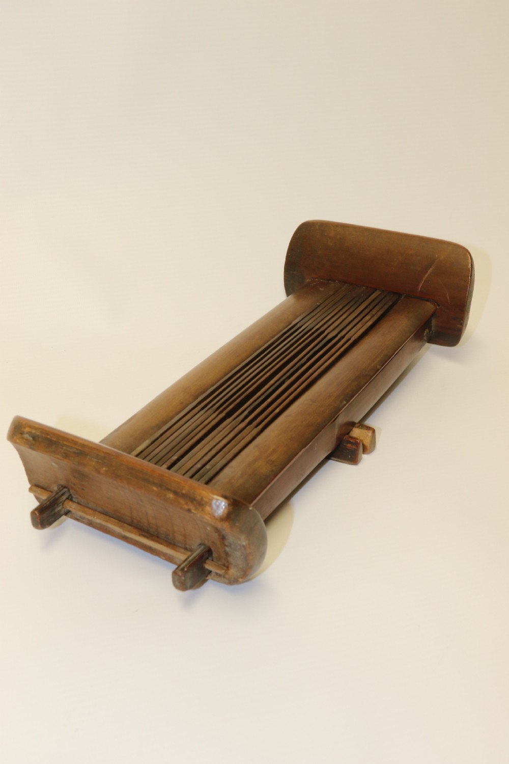 An eighteenth-century Chinese folding headrest crafted from dark bamboo and carved timber supports. View IX