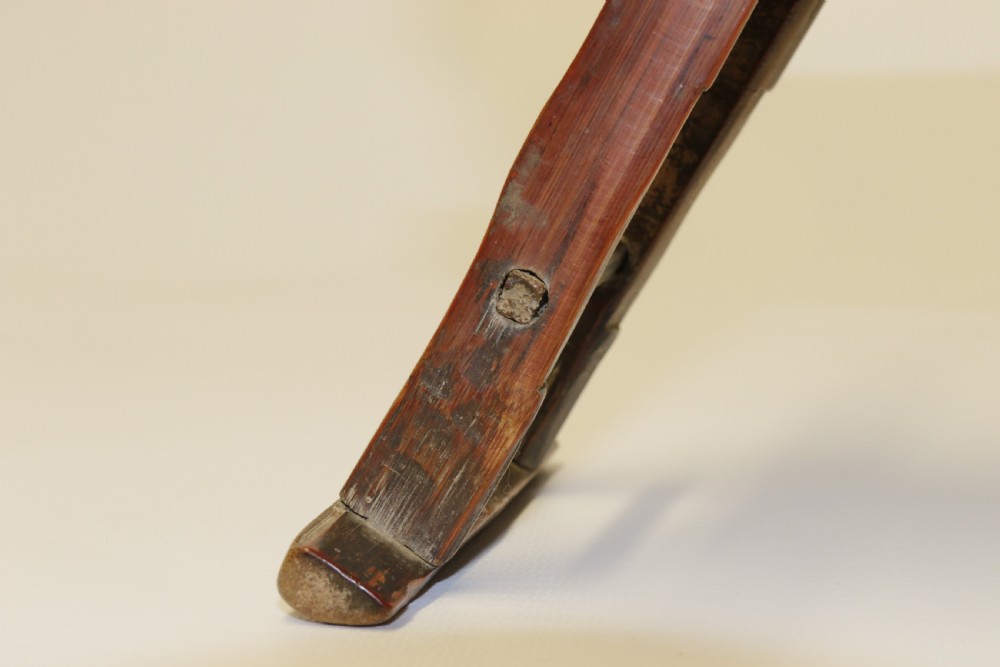 An eighteenth-century Chinese folding headrest crafted from dark bamboo and carved timber supports. View X