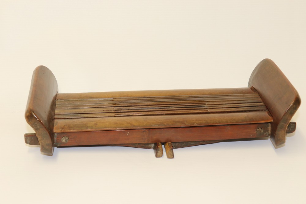 An eighteenth-century Chinese folding headrest crafted from dark bamboo and carved timber supports. View XII