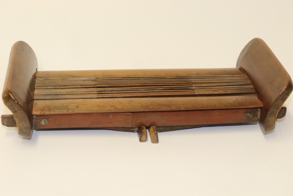An eighteenth-century Chinese folding headrest crafted from dark bamboo and carved timber supports. View XIII