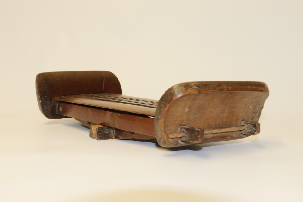 An eighteenth-century Chinese folding headrest crafted from dark bamboo and carved timber supports. View XV