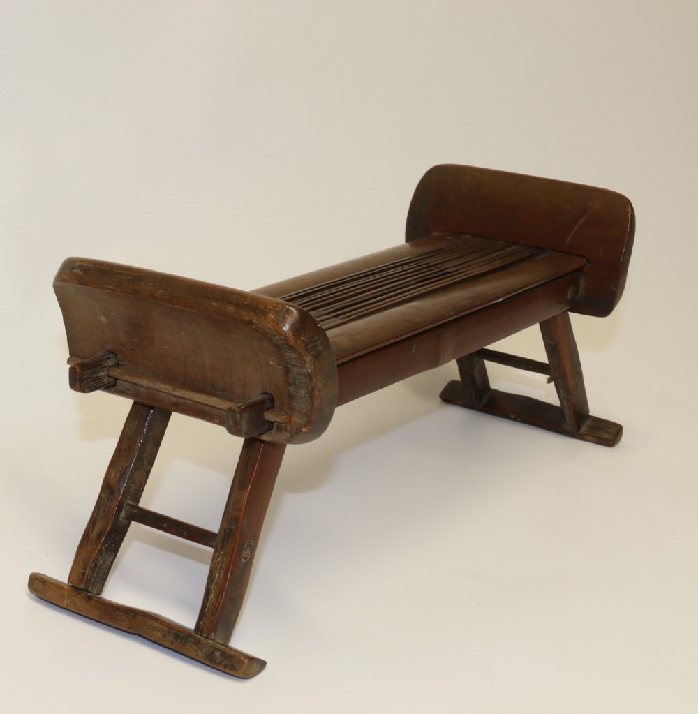 An eighteenth-century Chinese folding headrest crafted from dark bamboo and carved timber supports.