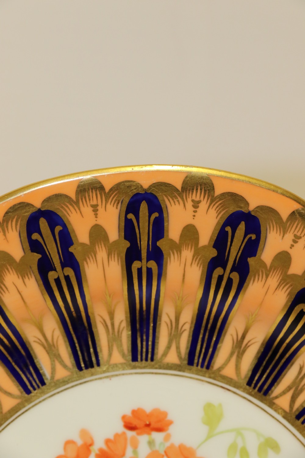 A pair of circular antique porcelain cabinet plates featuring central hand-painted floral motifs surrounded by elaborate gilded and cobalt blue borders. View V