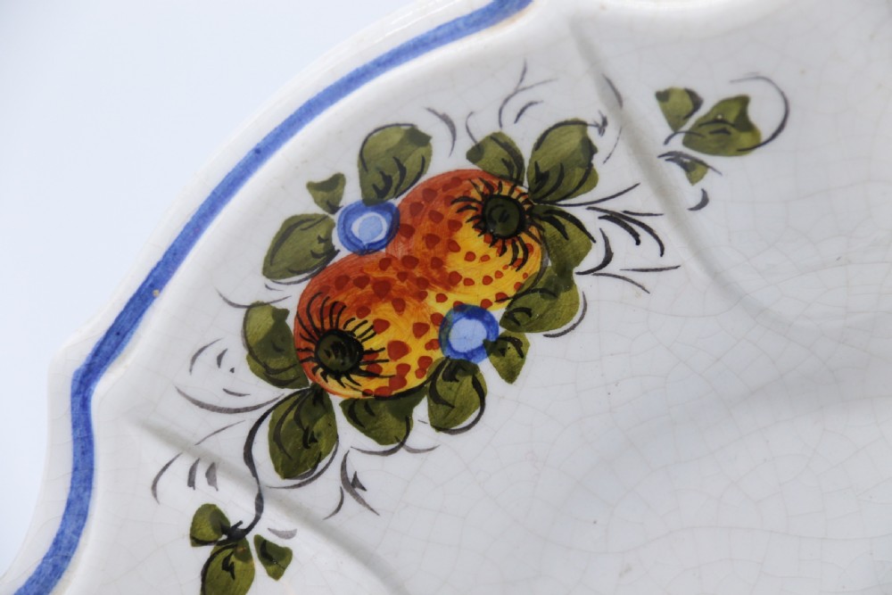 A circular tin-glazed earthenware wall charger featuring a hand-painted game bird in the centre surrounded by a scalloped, floral-decorated rim with blue edging. View VI