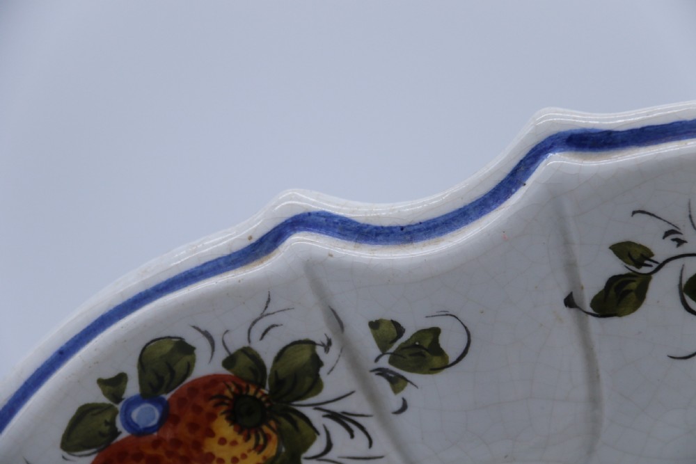A circular tin-glazed earthenware wall charger featuring a hand-painted game bird in the centre surrounded by a scalloped, floral-decorated rim with blue edging. View XI