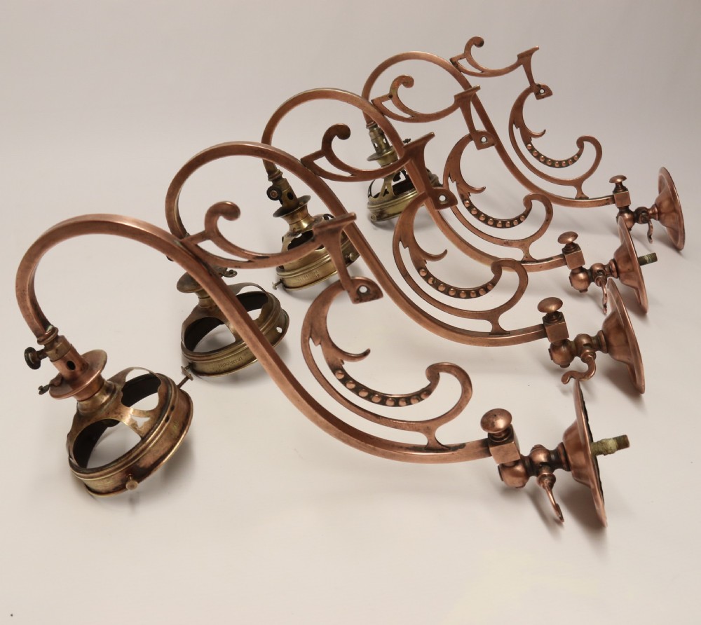 A stylish set of four early 20th century copper arts and crafts gas wall lights