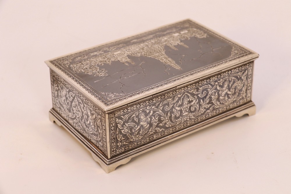 A rectangular sterling silver box featuring intricate black niello inlay artwork depicting a Thai temple architectural landscape on the lid and mythological figures along the sides. View III