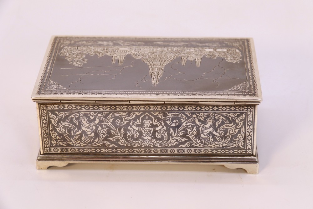 A rectangular sterling silver box featuring intricate black niello inlay artwork depicting a Thai temple architectural landscape on the lid and mythological figures along the sides. View VI