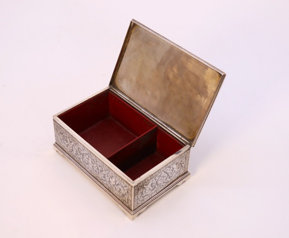 A rectangular sterling silver box featuring intricate black niello inlay artwork depicting a Thai temple architectural landscape on the lid and mythological figures along the sides. View IX