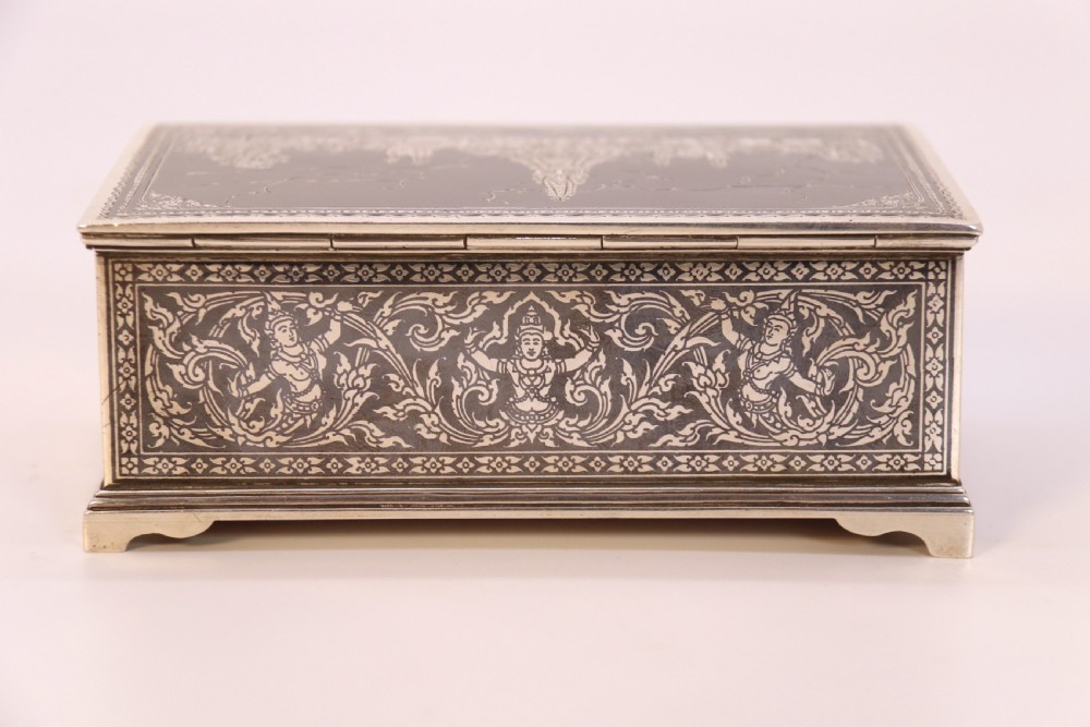 A rectangular sterling silver box featuring intricate black niello inlay artwork depicting a Thai temple architectural landscape on the lid and mythological figures along the sides. View XIV