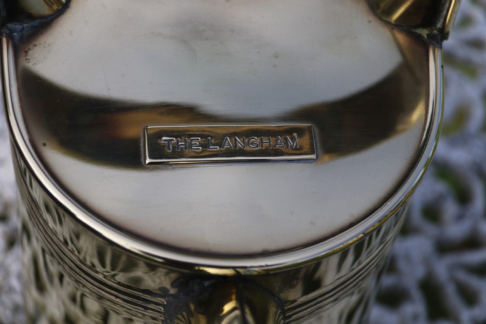 A pair of polished 19th-century brass watering cans in differing sizes featuring reeded cylindrical bodies, arched top handles, and angled spouts. View XXVIII