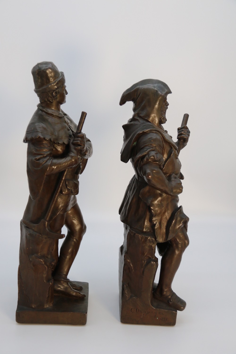 A pair of patinated electrotype bronze figures depicting historic tradesmen standing on rectangular plinths. View II