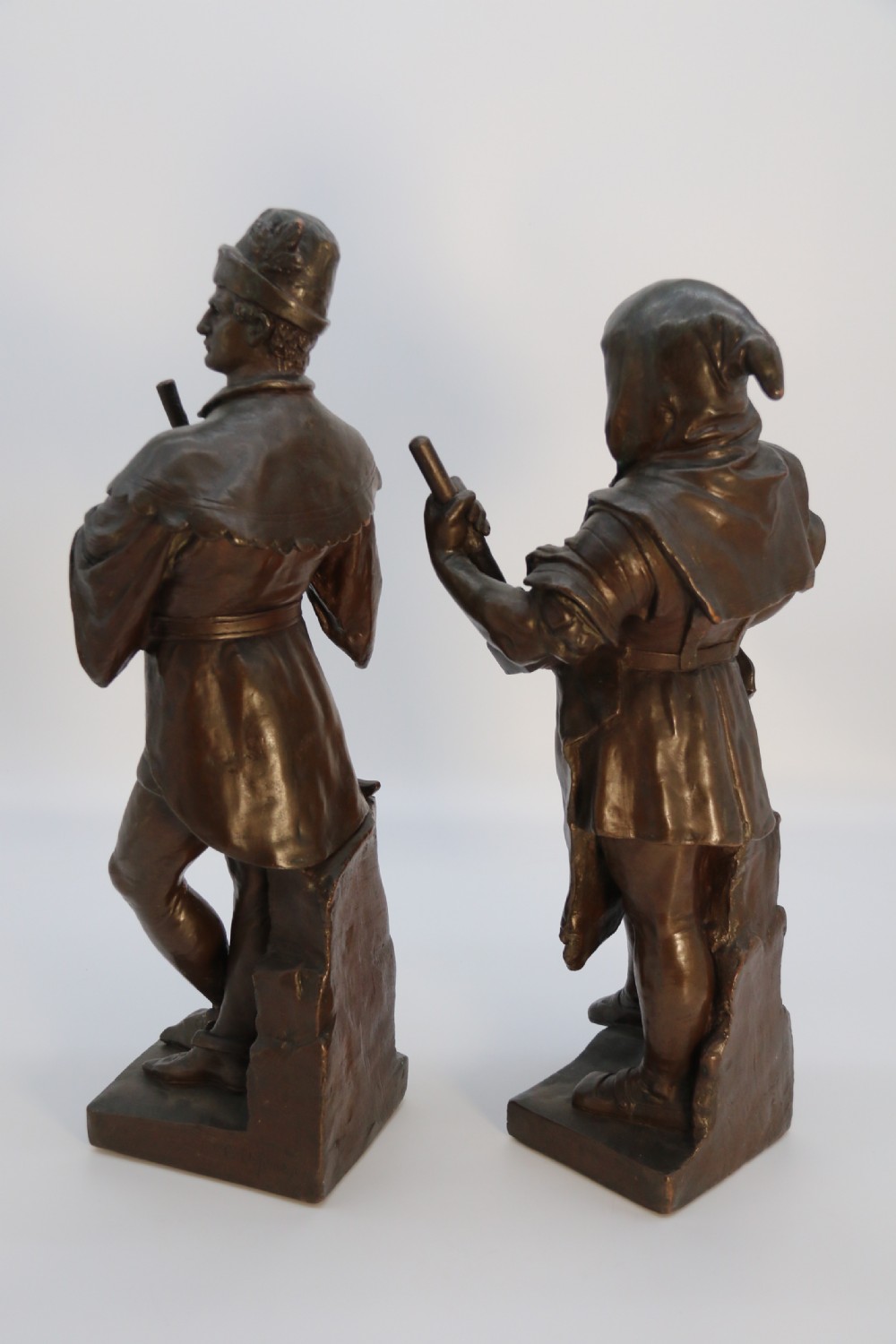 A pair of patinated electrotype bronze figures depicting historic tradesmen standing on rectangular plinths. View V