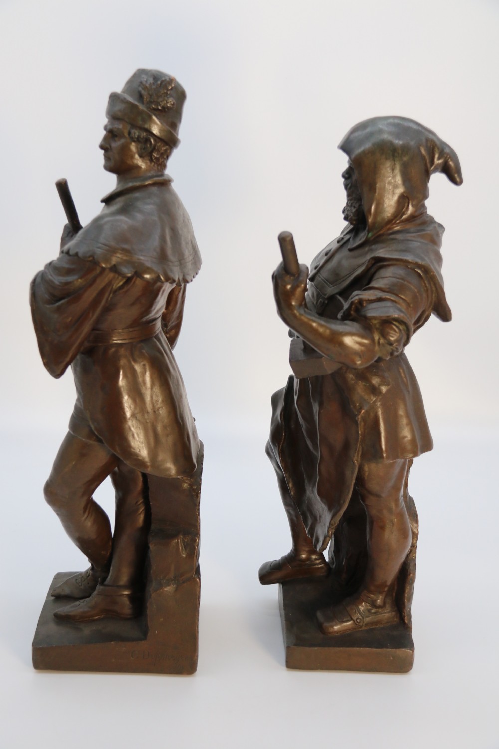 A pair of patinated electrotype bronze figures depicting historic tradesmen standing on rectangular plinths. View VI