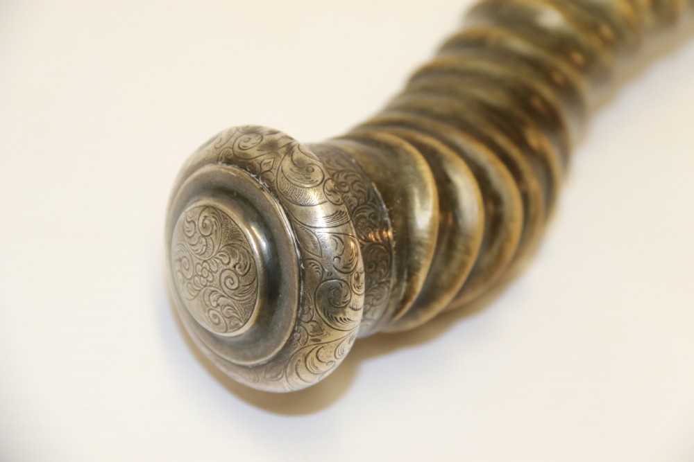 An early nineteenth-century roasting fork featuring a long, spiral horn handle with engraved silver mounts and a two-pronged steel tip. View II
