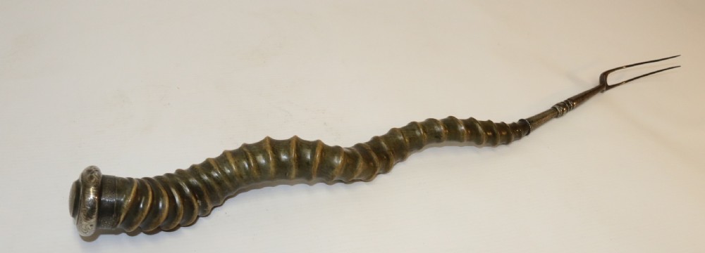 An early nineteenth-century roasting fork featuring a long, spiral horn handle with engraved silver mounts and a two-pronged steel tip. View III