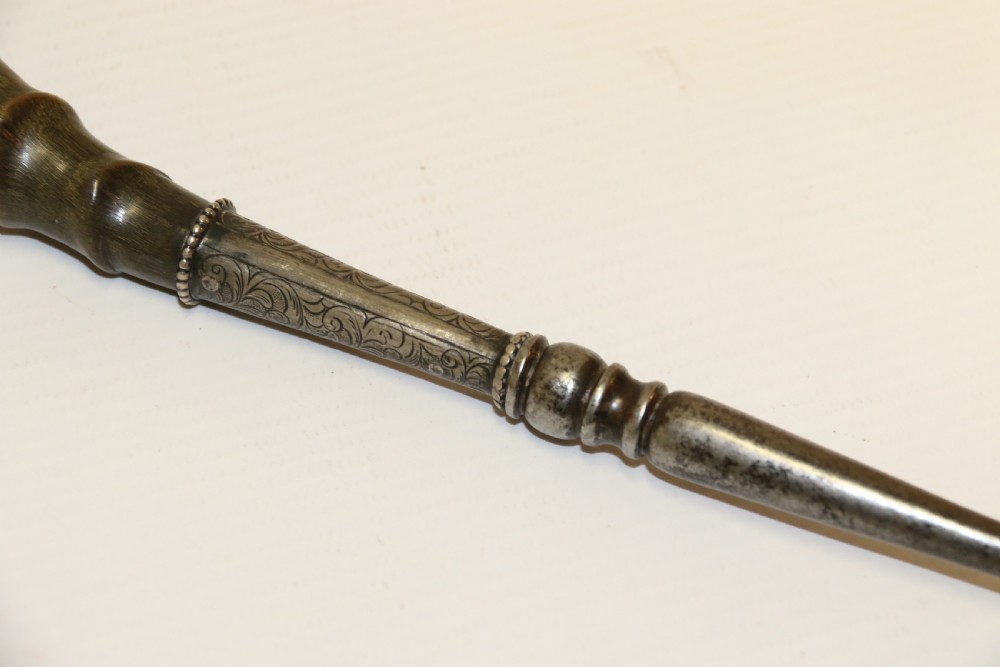 An early nineteenth-century roasting fork featuring a long, spiral horn handle with engraved silver mounts and a two-pronged steel tip. View VII
