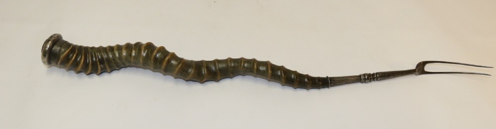 An early nineteenth-century roasting fork featuring a long, spiral horn handle with engraved silver mounts and a two-pronged steel tip. View XI
