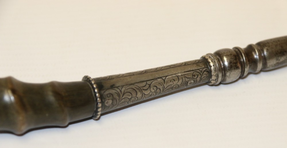 An early nineteenth-century roasting fork featuring a long, spiral horn handle with engraved silver mounts and a two-pronged steel tip. View XII